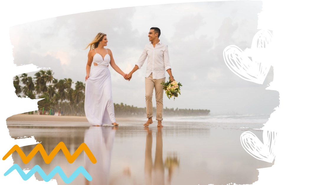 Couple in wedding attire walking on beach