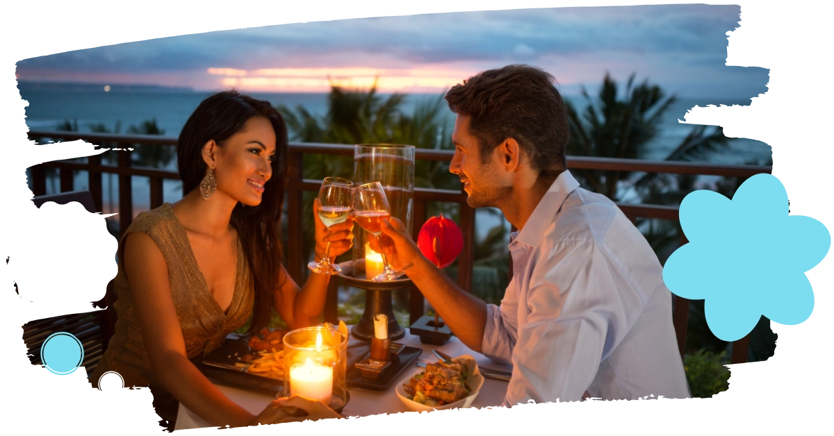 Couple toasting wine at sunset beach dinner