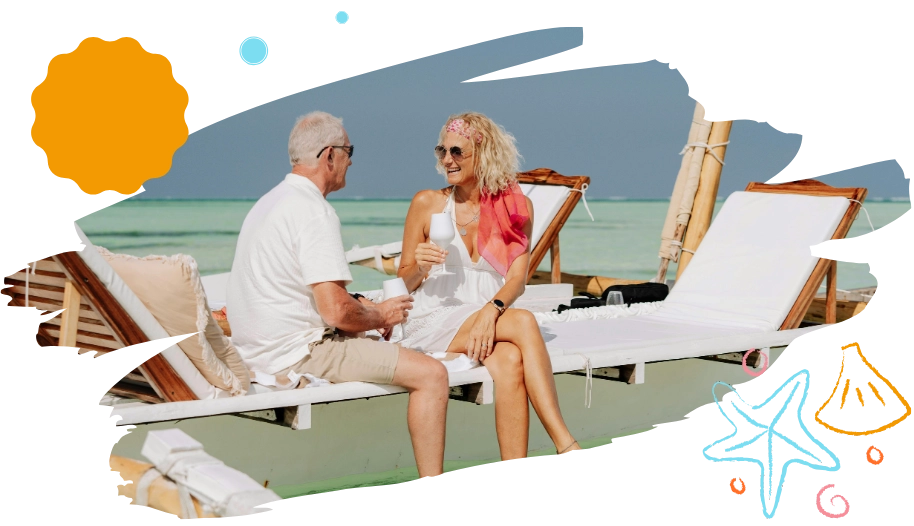 Senior couple smiling and talking while relaxing on a beach daybed in the sun.