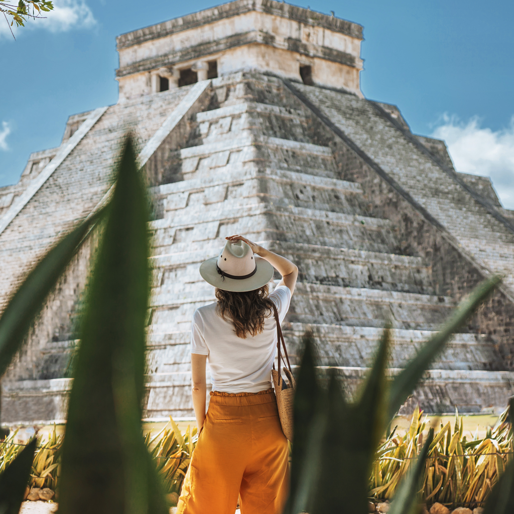 Ancient Mayan pyramid near Cancun with a tourist.